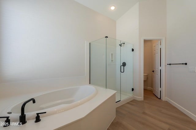 14771 W Columbus Ave, Goodyear, AZ 85395 - bathroom with a shower stall, a garden tub, wood finished floors, toilet, and baseboards