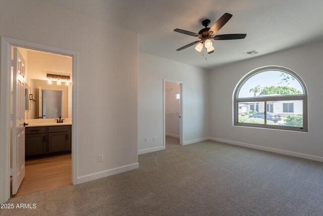 14771 W Columbus Ave, Goodyear, AZ 85395 - unfurnished bedroom with light colored carpet, a walk in closet, and baseboards
