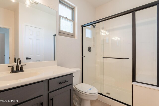 14771 W Columbus Ave, Goodyear, AZ 85395 - bathroom featuring a shower stall, toilet, vanity, and a chandelier