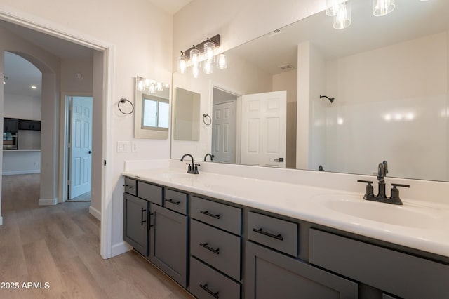 14771 W Columbus Ave, Goodyear, AZ 85395 - bathroom featuring wood finished floors, double vanity, and baseboards