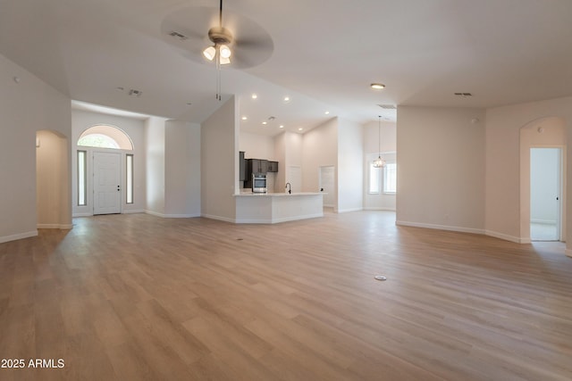 14771 W Columbus Ave, Goodyear, AZ 85395 - unfurnished living room featuring arched walkways, a ceiling fan, baseboards, high vaulted ceiling, and recessed lighting