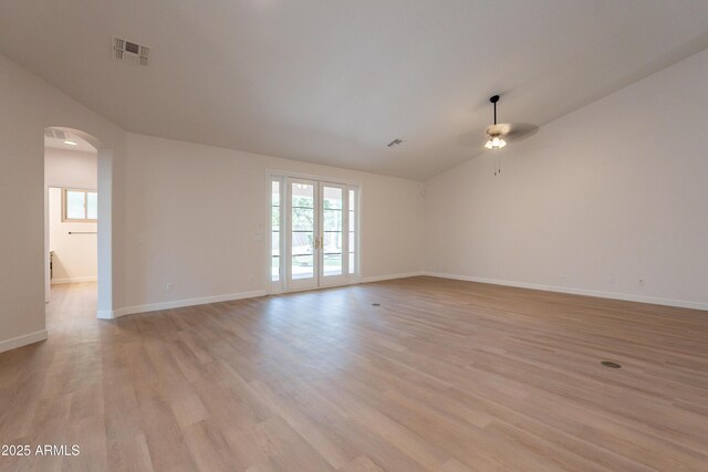 14771 W Columbus Ave, Goodyear, AZ 85395 - spare room with vaulted ceiling, arched walkways, a ceiling fan, light wood-style floors, and baseboards