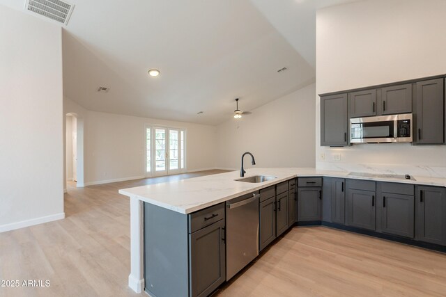 14771 W Columbus Ave, Goodyear, AZ 85395 - kitchen with appliances with stainless steel finishes, a sink, a peninsula, gray cabinets, and vaulted ceiling