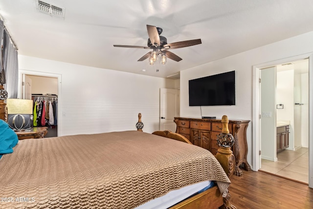 25218 W Carson Ct, Buckeye, AZ 85326 - bedroom with wood finished floors, a ceiling fan, and a walk in closet