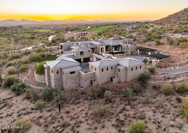 aerial view at dusk featuring a mountain view