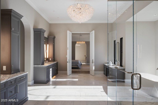 bathroom with a notable chandelier, crown molding, a bath, and vanity