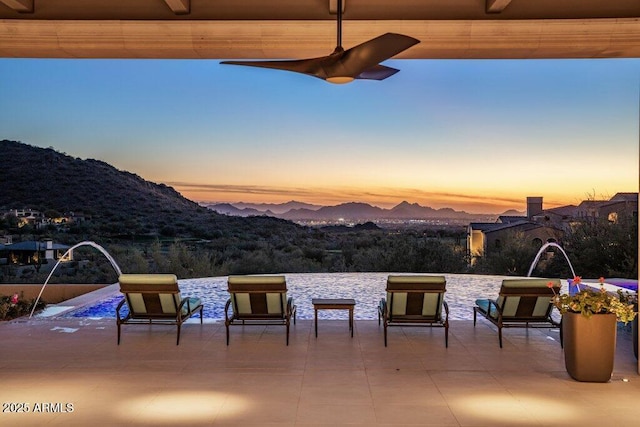 patio terrace at dusk featuring a mountain view