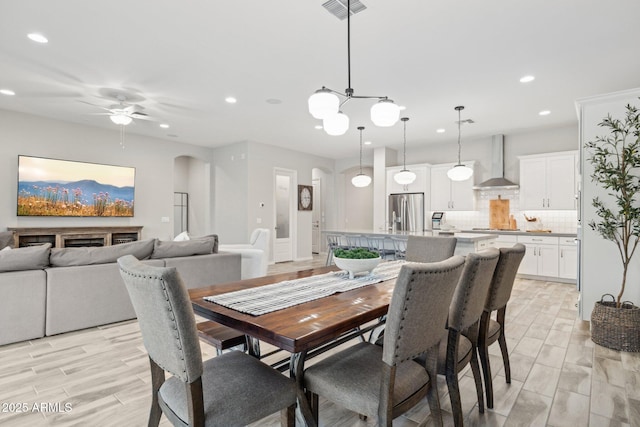 dining space with arched walkways, ceiling fan, recessed lighting, wood finish floors, and visible vents
