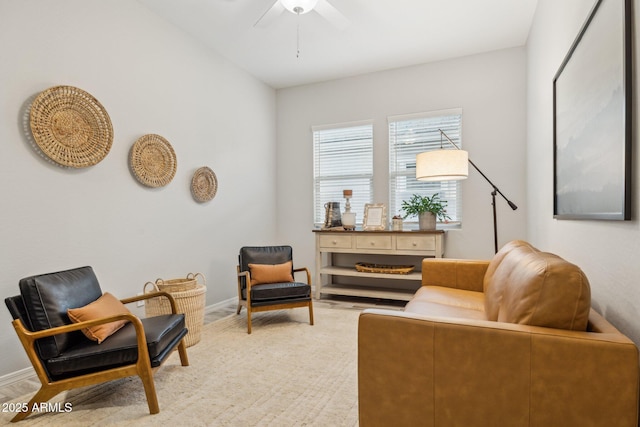 sitting room with ceiling fan and baseboards