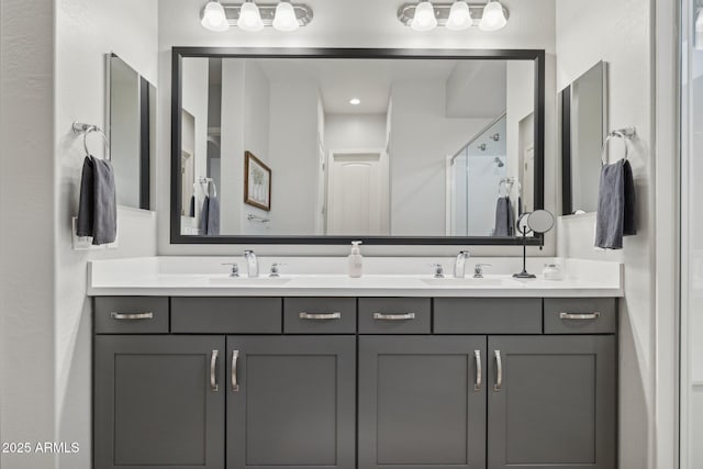 full bathroom with double vanity, a stall shower, and a sink