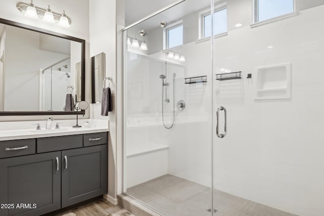 full bath with a stall shower and vanity