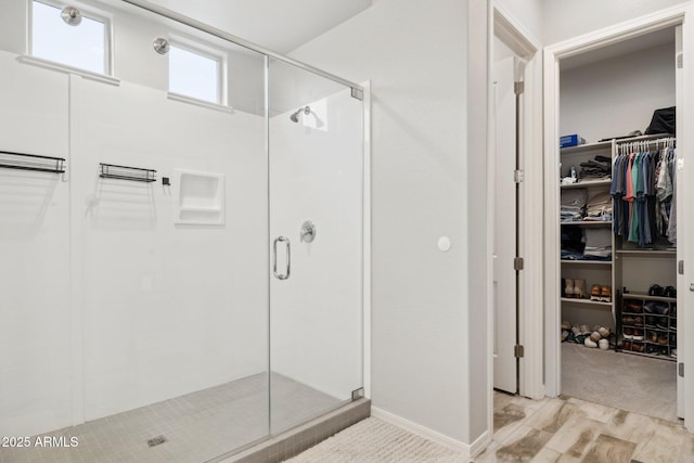 full bath with a shower stall, a spacious closet, and wood finished floors