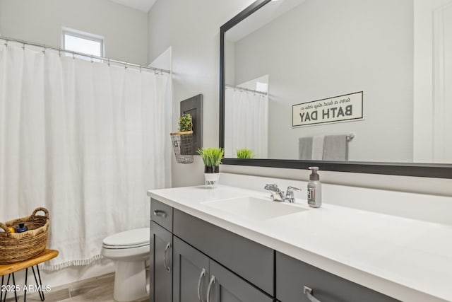 bathroom featuring toilet, wood finished floors, and vanity