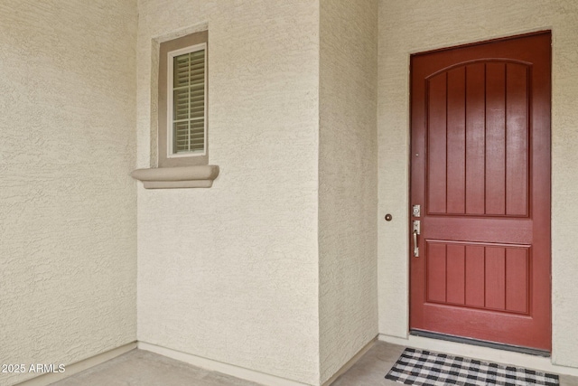 view of exterior entry featuring stucco siding