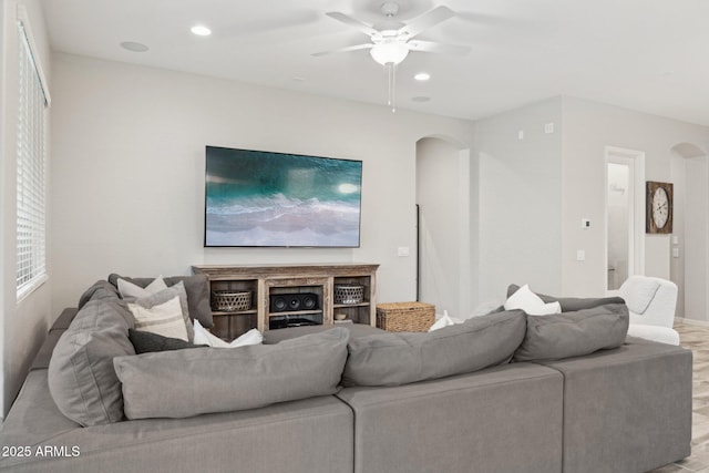 living area featuring arched walkways, wood finished floors, a ceiling fan, and recessed lighting