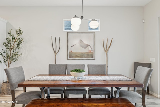 dining room featuring light wood-type flooring and baseboards
