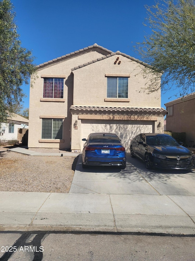 view of front of house featuring concrete driveway, an attached garage, a tiled roof, and stucco siding