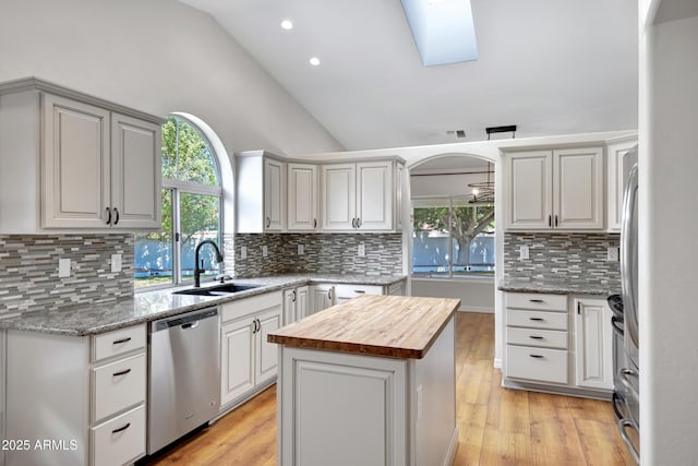 811 S Pearl Dr, Gilbert, AZ 85233 - kitchen with a center island, lofted ceiling with skylight, a sink, wood counters, and stainless steel appliances
