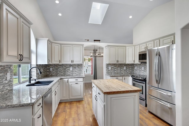 811 S Pearl Dr, Gilbert, AZ 85233 - kitchen featuring a center island, a sink, a skylight, wood counters, and appliances with stainless steel finishes