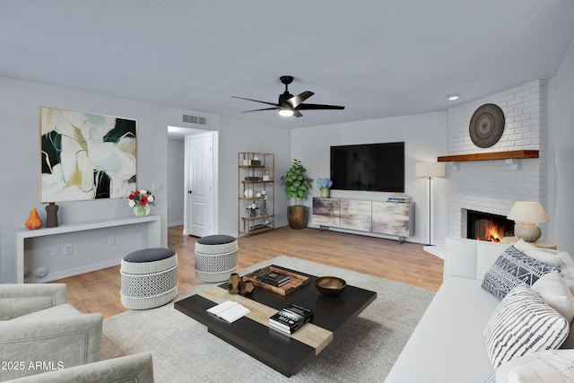 811 S Pearl Dr, Gilbert, AZ 85233 - living area with a brick fireplace, wood finished floors, visible vents, and a ceiling fan
