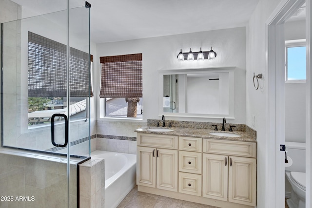 811 S Pearl Dr, Gilbert, AZ 85233 - bathroom featuring a garden tub, toilet, tile patterned floors, and a sink
