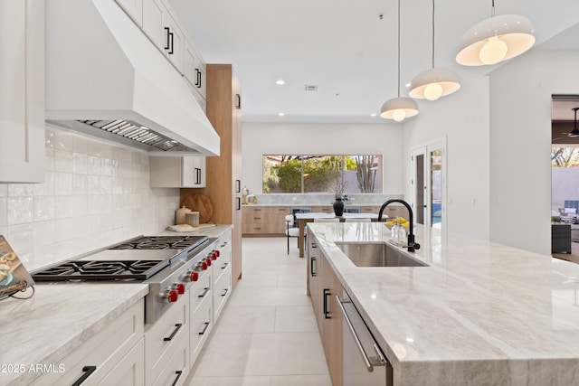 kitchen featuring sink, white cabinetry, and hanging light fixtures