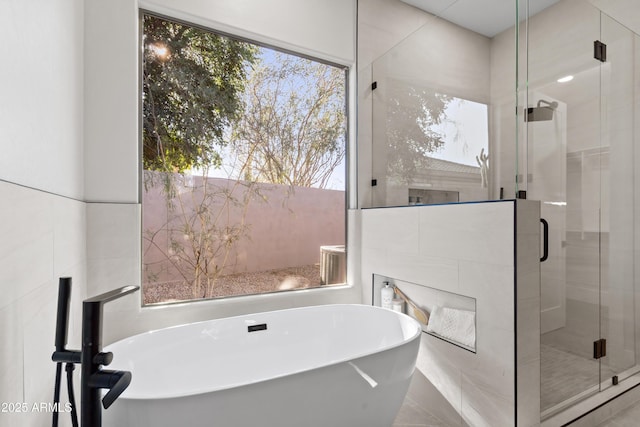 bathroom featuring shower with separate bathtub