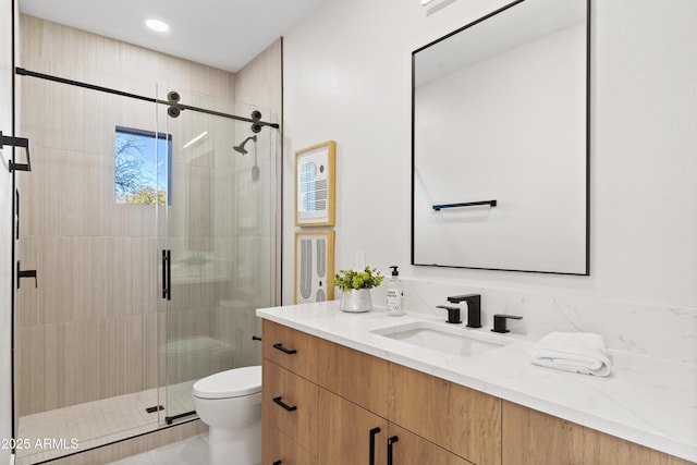 bathroom featuring toilet, vanity, tile patterned floors, and a shower with shower door