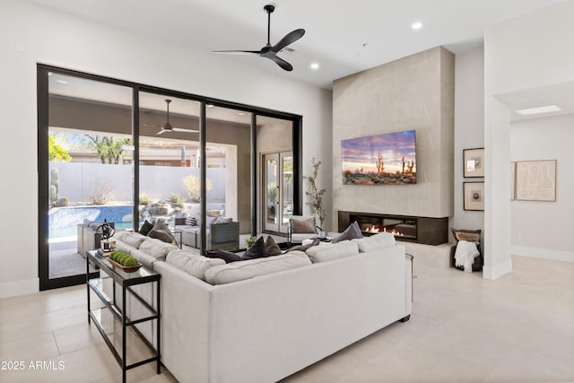 living room with ceiling fan and a fireplace