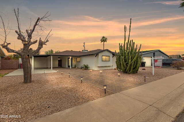 view of front facade featuring an attached carport and decorative driveway