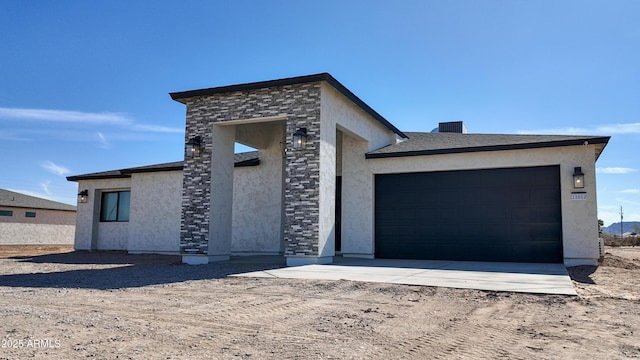 view of front of property featuring stucco siding, a garage, and dirt driveway