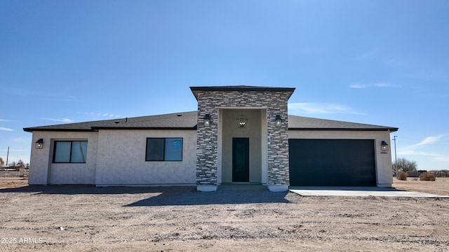 view of front of house featuring a garage, stucco siding, and stone siding