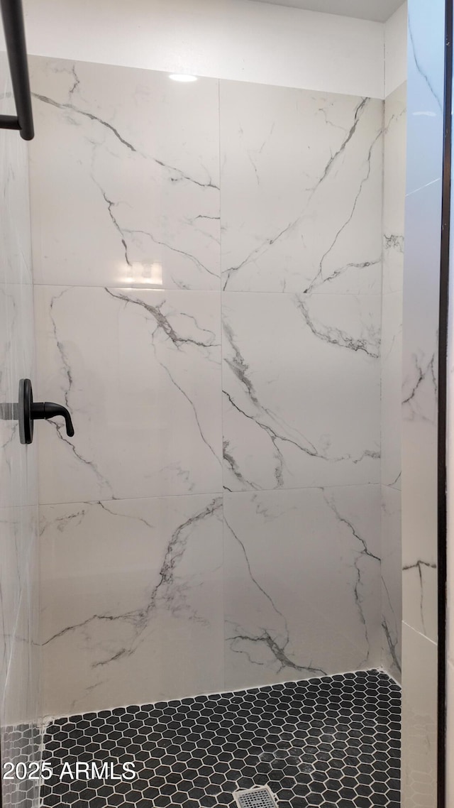 bathroom featuring a marble finish shower