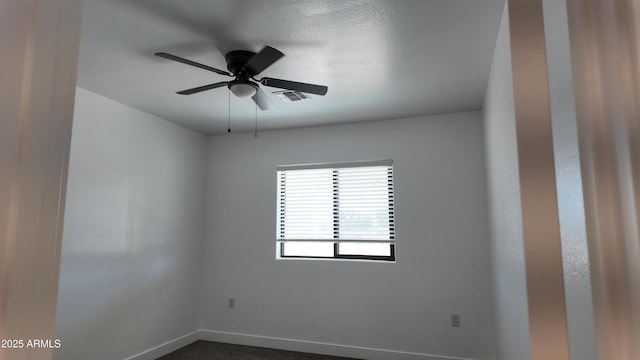 empty room featuring baseboards and ceiling fan