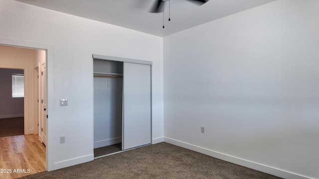 unfurnished bedroom with baseboards, a closet, and carpet flooring