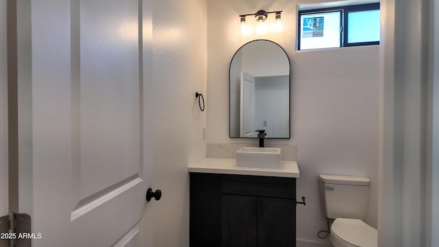 half bathroom with vanity and toilet
