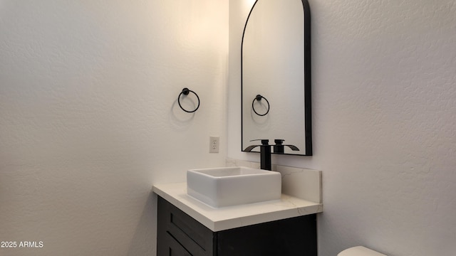 bathroom with vanity and a textured wall