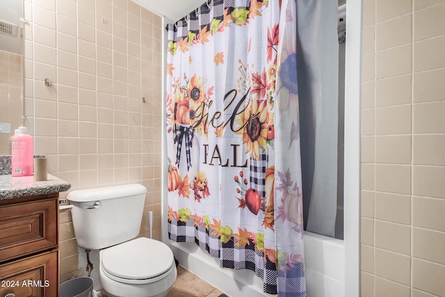 full bathroom with shower / bath combo with shower curtain, tile patterned floors, toilet, tile walls, and vanity