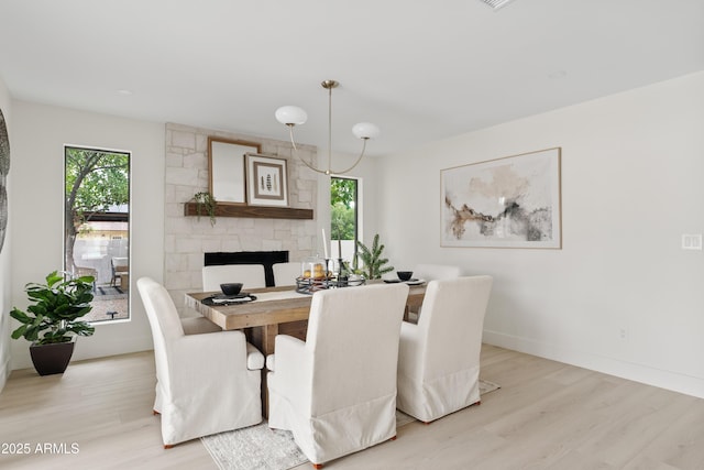 dining room with a healthy amount of sunlight, light wood-style floors, and baseboards