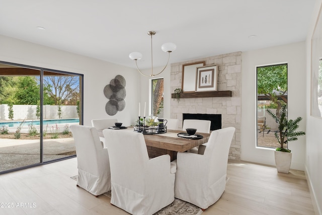 dining space with light wood-style flooring and a fireplace