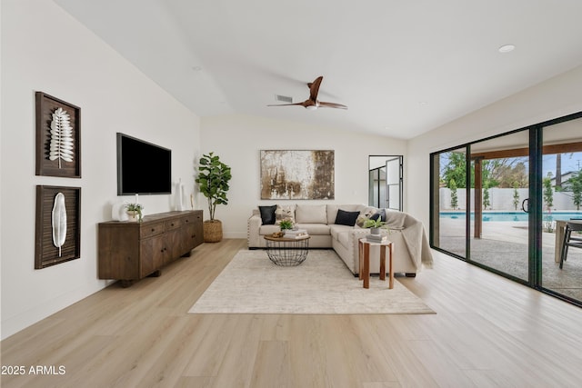 living room featuring lofted ceiling, visible vents, light wood-style flooring, a ceiling fan, and baseboards