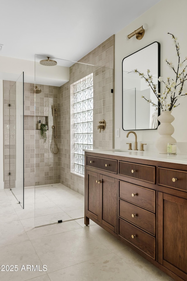 bathroom featuring walk in shower, vanity, tile walls, and tile patterned floors