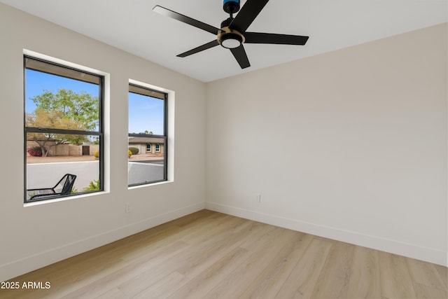 spare room with light wood-style floors, ceiling fan, and baseboards