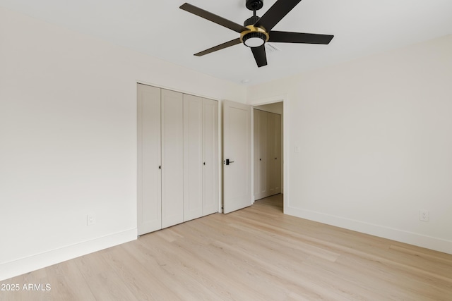 unfurnished bedroom featuring a ceiling fan, light wood-type flooring, a closet, and baseboards