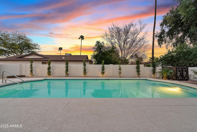 pool at dusk featuring a fenced backyard, a fenced in pool, and a patio