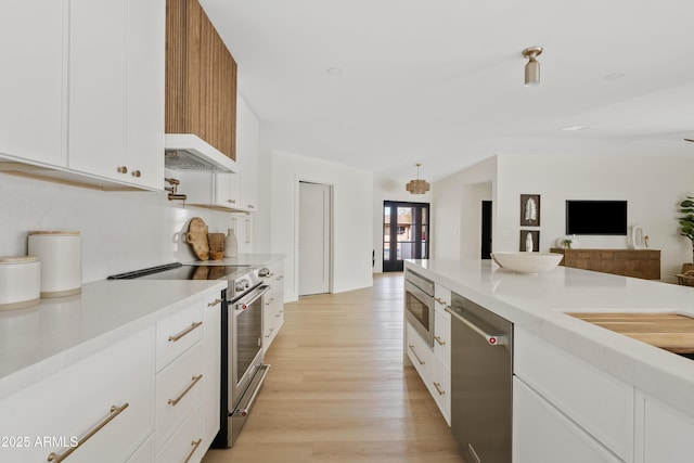 kitchen featuring under cabinet range hood, white cabinets, light countertops, appliances with stainless steel finishes, and light wood finished floors