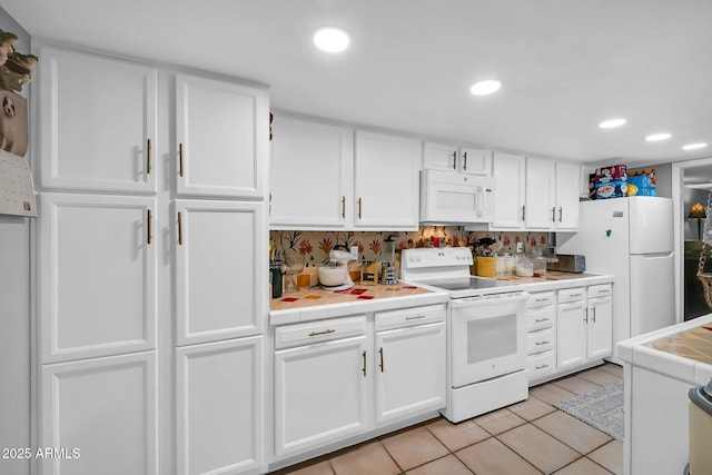 1924 W Belmont Ave, Phoenix, AZ 85021 - kitchen featuring white cabinets, recessed lighting, tile countertops, light tile patterned floors, and white appliances