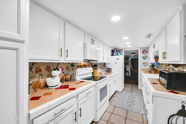 1924 W Belmont Ave, Phoenix, AZ 85021 - kitchen featuring white cabinets, tile counters, visible vents, light tile patterned floors, and white appliances
