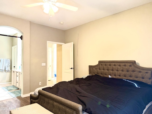 bedroom featuring hardwood / wood-style floors, ensuite bath, and ceiling fan