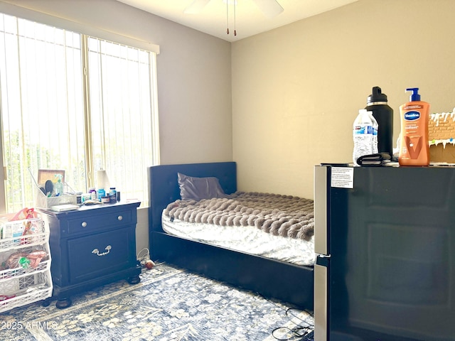 bedroom with multiple windows and stainless steel fridge